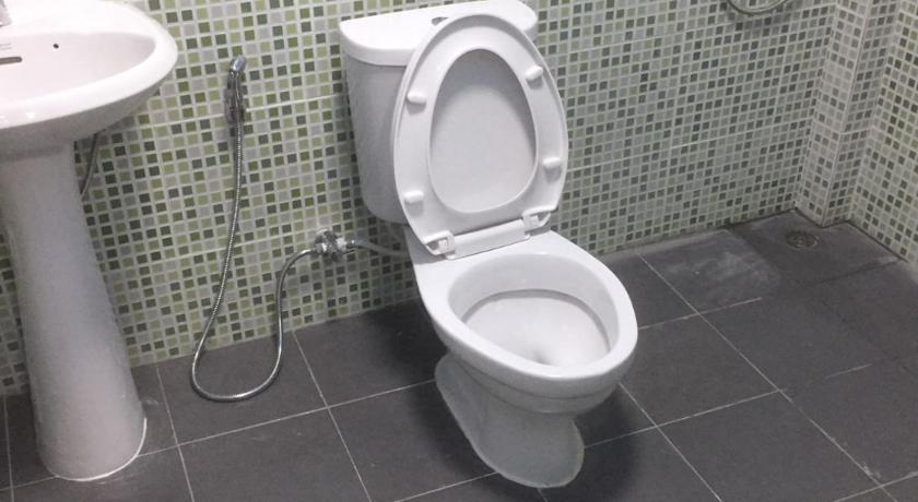 a white toilet sitting in a bathroom next to a sink, น้ำอ้อย-สุชาดา รีสอร์ท in Tak
