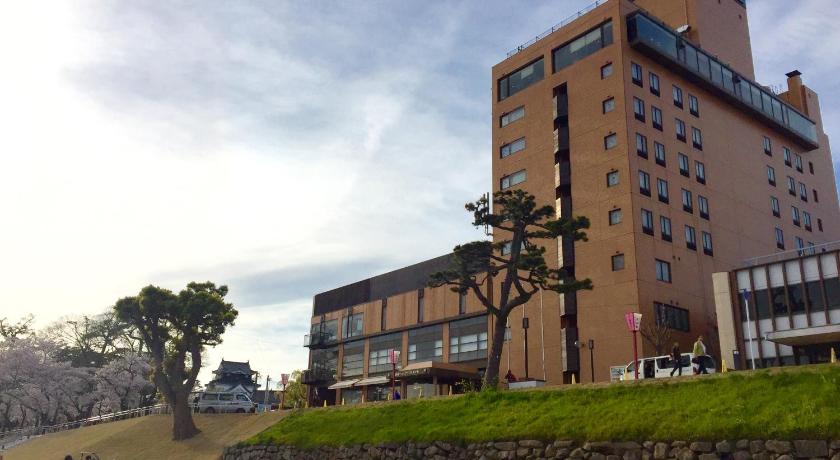 a large building with a clock on the side of it, Okazaki New Grand Hotel in Okazaki