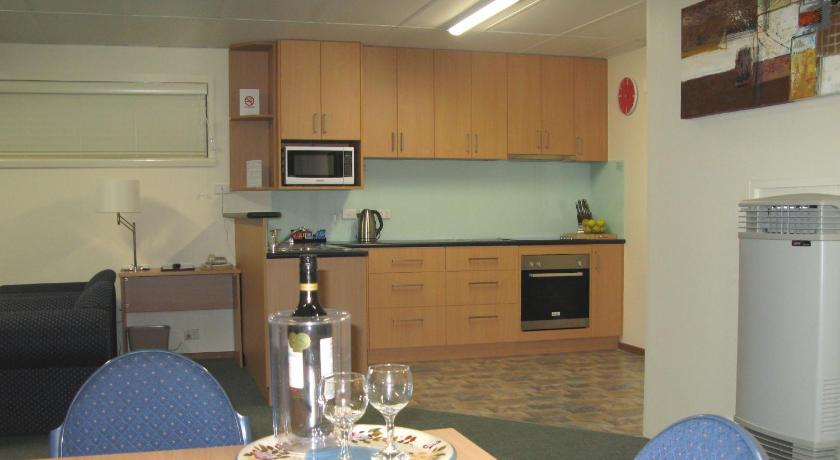 a kitchen with a table, chairs and a microwave, Barclay Motor Inn in Devonport