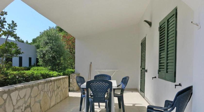 a dining room table with chairs and a patio, Villaggio San Lorenzo in Vieste