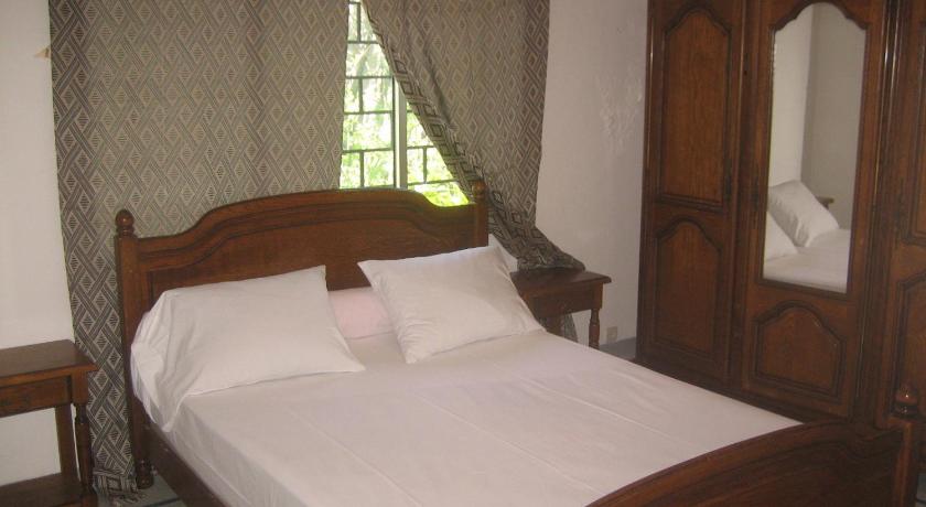 a bedroom with a bed and a dresser, Farida Lodge in Moroni