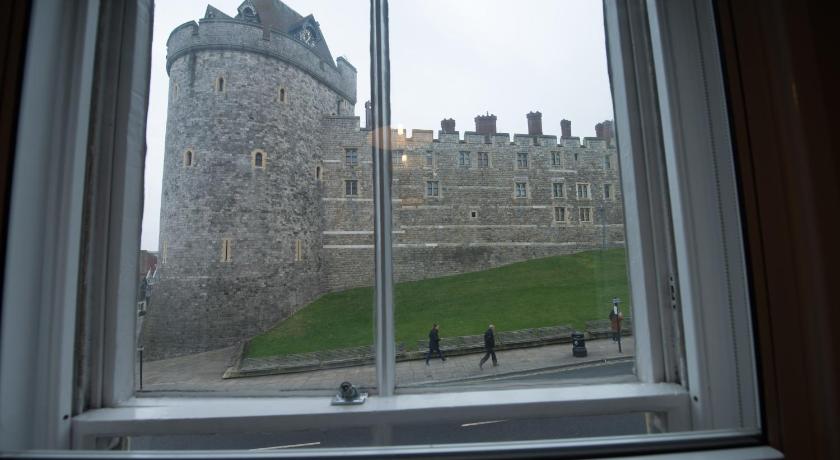 a view from a window of a building with a clock on it, Central Windsor Apartment Facing the Castle in London