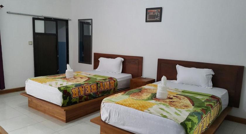 a hotel room with two beds and two nightstands, Jo Homestay in Lombok