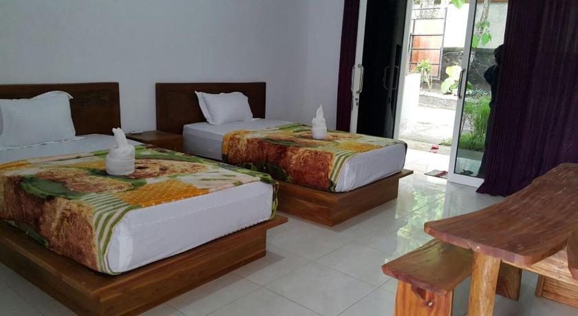 two beds in a room with wooden floors, Jo Homestay in Lombok