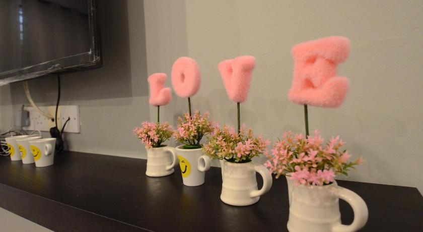 a row of vases filled with pink flowers on top of a counter, Decozy Homestay (14pax++) in Ipoh