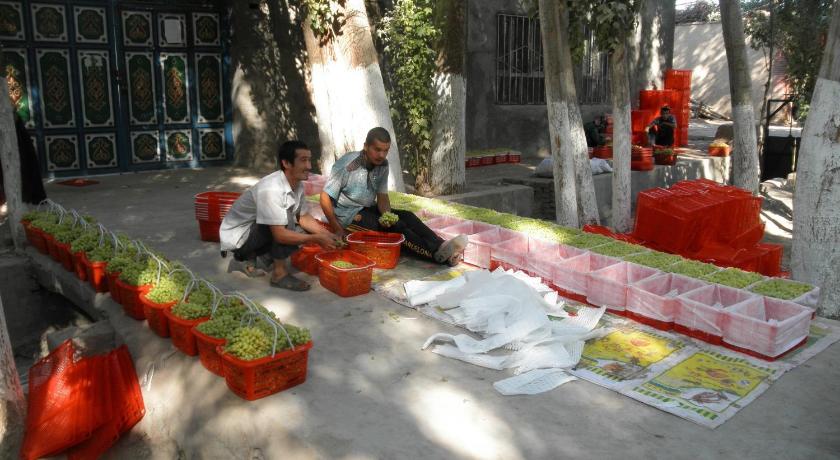 people sitting on a bench in the middle of a park, Silk Road Lodges in Turpan