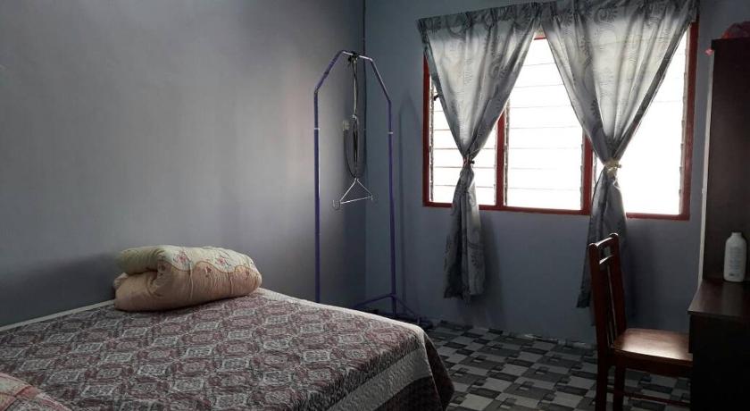 a bedroom with a bed and a dresser, Homestay Ustaz in Taiping