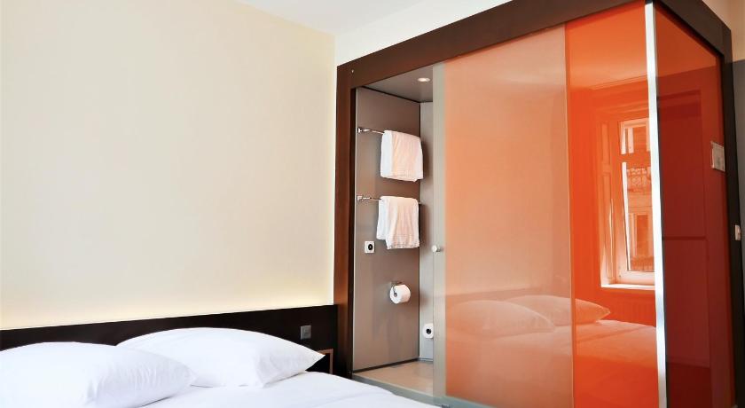 a bedroom with a bed and a dresser, easyHotel Zurich in Zürich