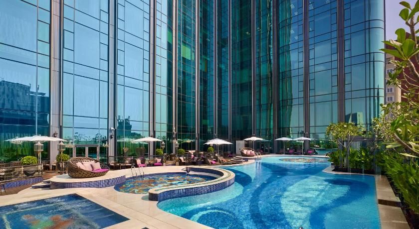 a large swimming pool in front of a large building, The Reverie Saigon Residential Suites in Ho Chi Minh City