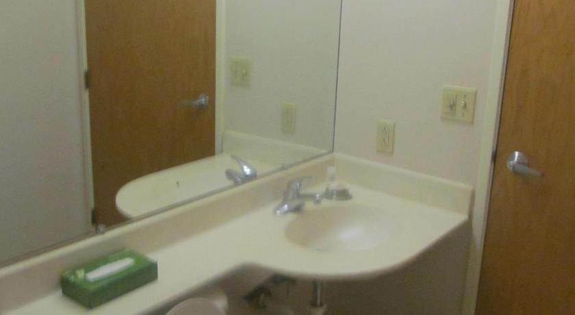 a bathroom with a toilet, sink, and mirror, Microtel Inn by Wyndham Champaign in Champaign (IL)
