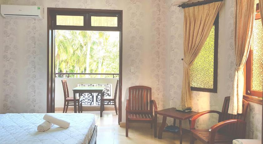 a room with a bed, chair, table and a window, Delight Hotel Mui Ne in Phan Thiet