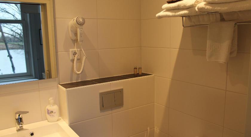 a white toilet sitting next to a sink in a bathroom, Hotel van Dijk in Kampen