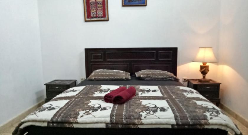 a bedroom with a bed and a lamp, Rumah Panjaitan in Yogyakarta