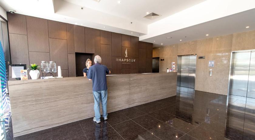 a man standing in a kitchen next to a counter, Rhapsody Resort in Gold Coast