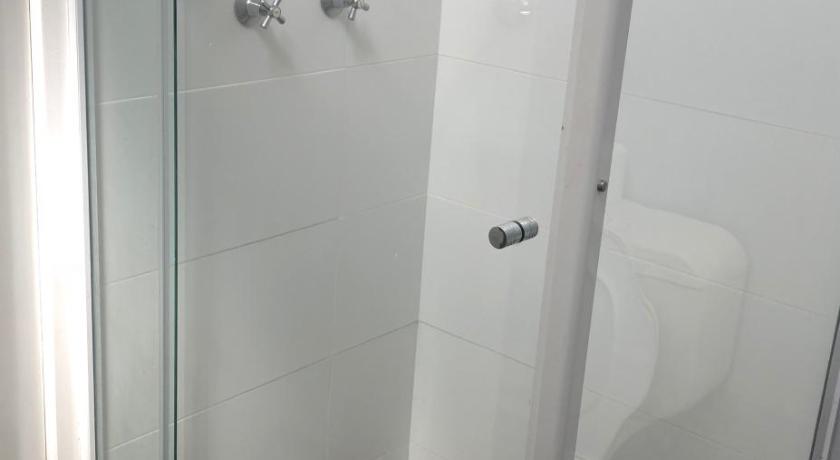 a shower stall with a toilet and a shower curtain, Bateau Bay Hotel in Bateau Bay