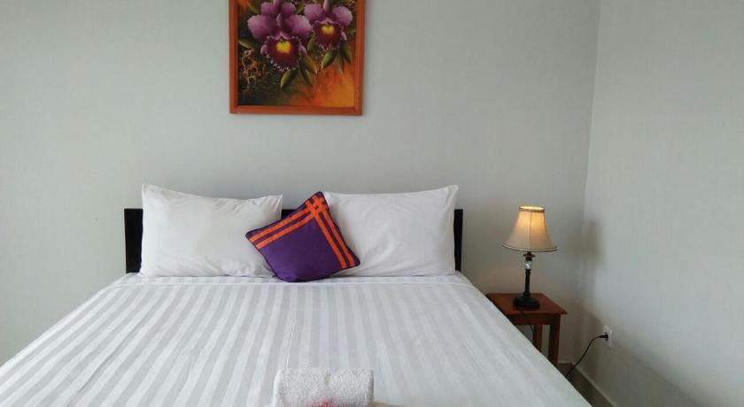 a bed with a white bedspread and pillows, CF Komodo Hotel in Labuan Bajo