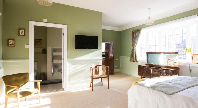 a room with a bed and a television, Bournville Bed and Breakfast in Birmingham