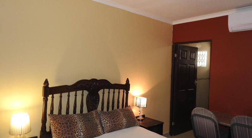 a bedroom with a bed and a lamp, Rose of Sharon in Durban