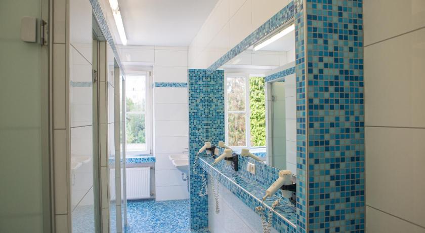 a bathroom with a blue tile floor and white walls, YoHo - International Youth Hostel in Salzburg