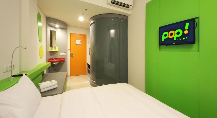 a room with a blue wall and a white bed, POP! Hotel Airport Jakarta in Jakarta