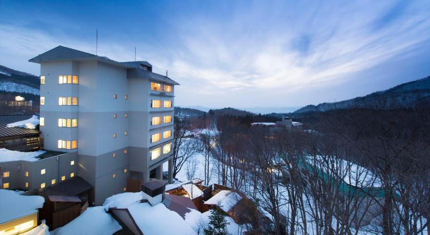 a snow covered ski slope with a building, Takamiya Hotel Lucent in Yamagata