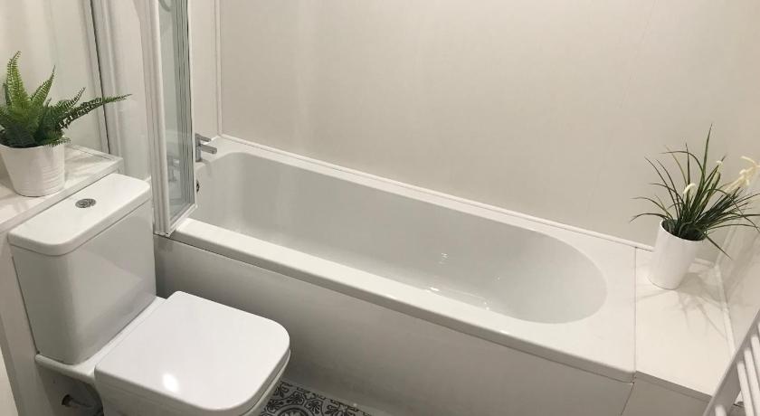 a white toilet sitting next to a bath tub, The Shaftesbury in Glasgow