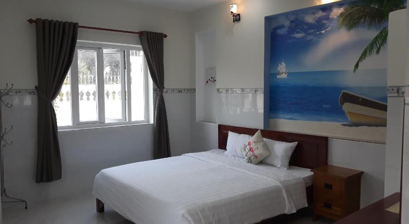 a bedroom with a large bed and a large window, Queen Motel Vung Tau in Vung Tau