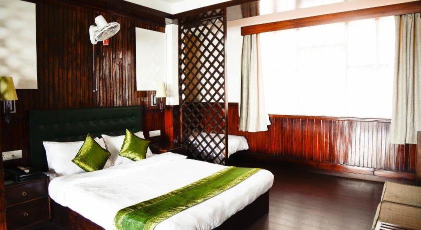 a bedroom with a bed and a dresser, The Nettle and Fern Hotel in Gangtok