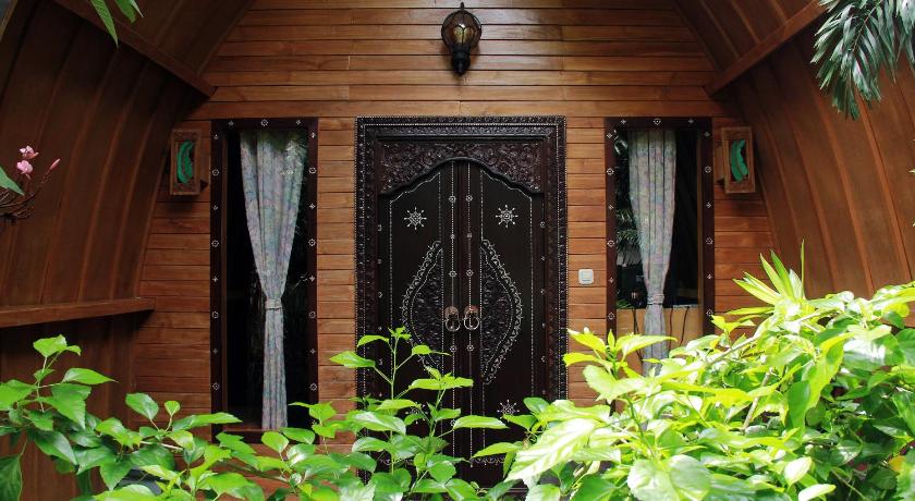 a wooden door leading to a room with a plant growing out of it, Banana Leaf Bungalow in Lombok