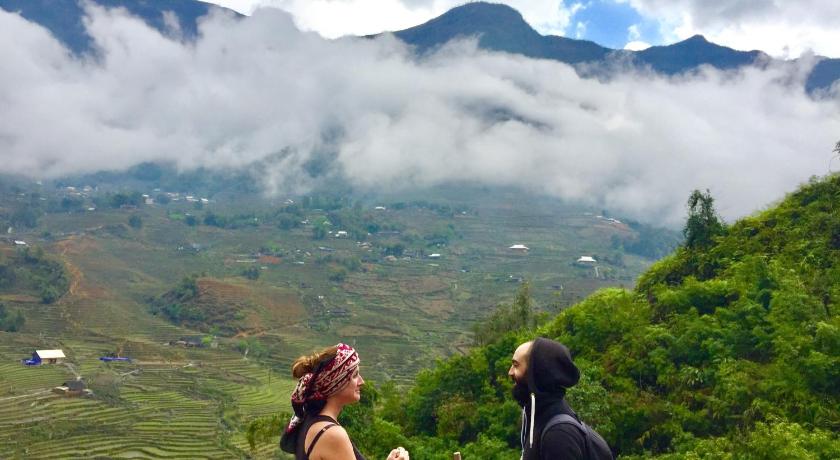 a man and a woman standing on top of a lush green hillside, Freedom Homestay & Trekking in Sapa