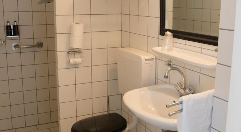a white toilet sitting in a bathroom next to a sink, Hof van Putten in Putten