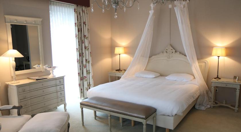 a hotel room with a bed and two lamps, Hof van Putten in Putten