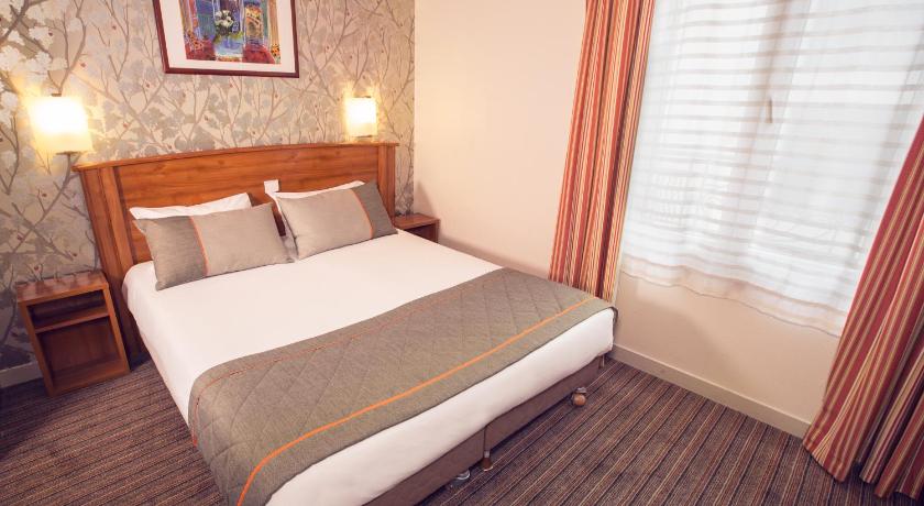 a hotel room with a large bed and a large window, Timhotel Tour Eiffel in Paris