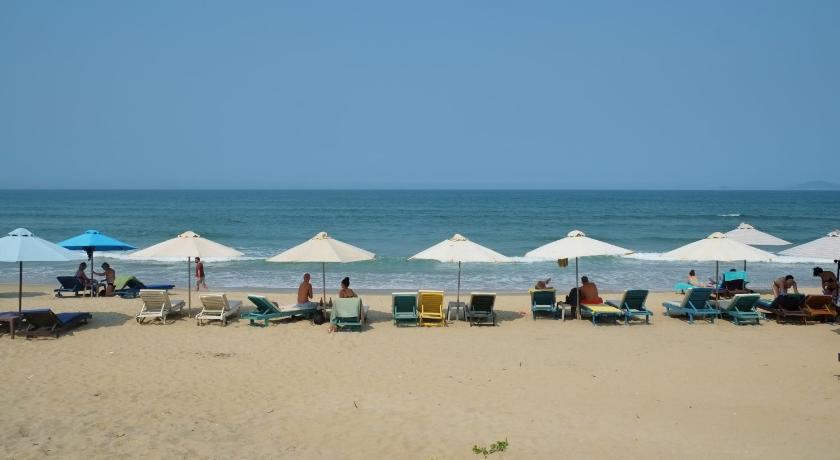 a sandy beach with umbrellas on the sand, Hoi An Corner Homestay in Hội An