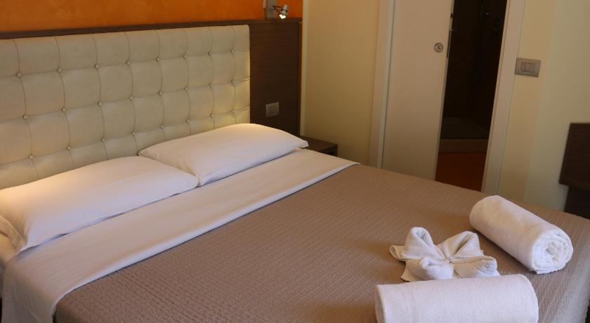 a hotel room with a white bed and white towels, Hotel La Madonnina in Milan