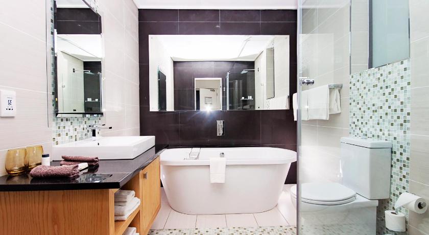 a bathroom with a sink, toilet and bathtub, Isango Gate Boutique Hotel and Spa in Port Elizabeth