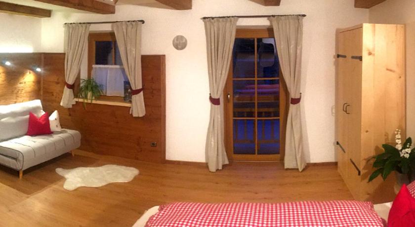 a room with a bed, a table and a dresser, Vorderponholz Ferienwohnungen in Ramsau