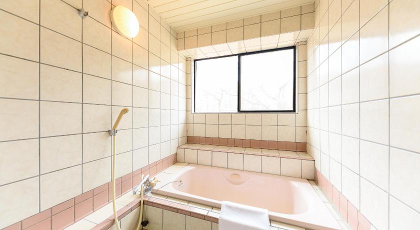 a bath tub sitting next to a window in a bathroom, Ginga no Yado Kinoko2seigo in Kokonoe