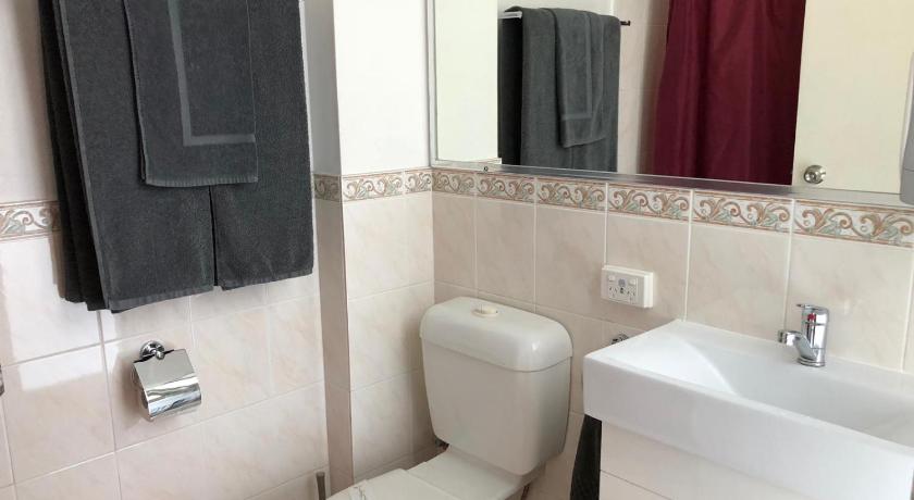a bathroom with a toilet, sink, and mirror, Goulburn Motor Inn in Goulburn