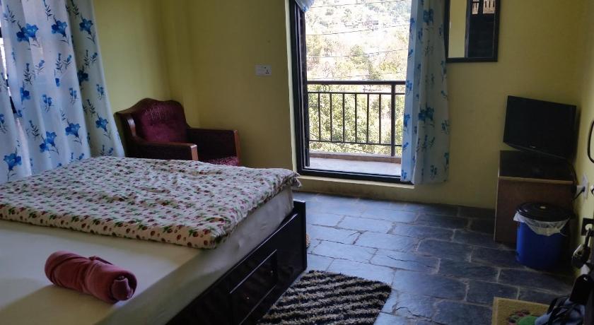 a bedroom with a bed and a window, Hotel Sanskaar in Bandipur