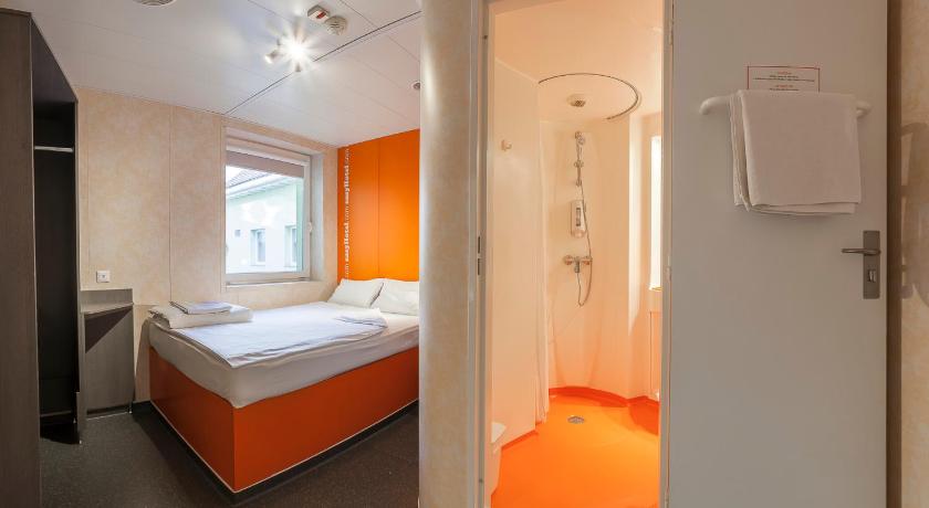 a hotel room with a bed and a shower, easyHotel Budapest Oktogon in Budapest