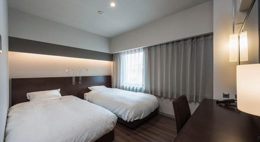 a hotel room with two beds and two lamps, Nagoya Kanayama Hotel in Nagoya