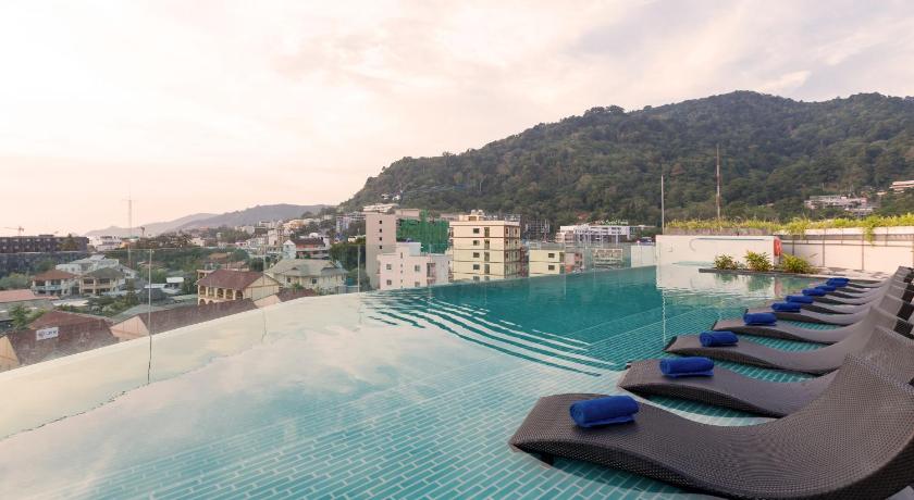 a swimming pool with a bunch of chairs on top of it, Oakwood Hotel Journeyhub Phuket  (SHA Extra Plus) in Phuket