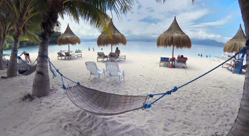 a beach with a beach chair and a beach umbrella, Aquarius - Port Barton in Palawan