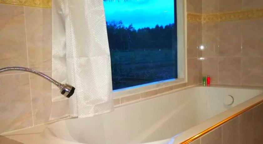 a bathroom with a bath tub and a window, View Dao Jantra in Chachoengsao