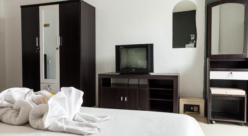 a hotel room with a bed, television and a dresser, Happy Fish Guesthouse in Phuket