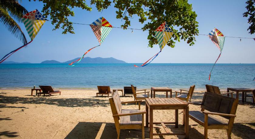 a beach area with chairs, tables and umbrellas, The Tropical Beach Resort in Koh Chang