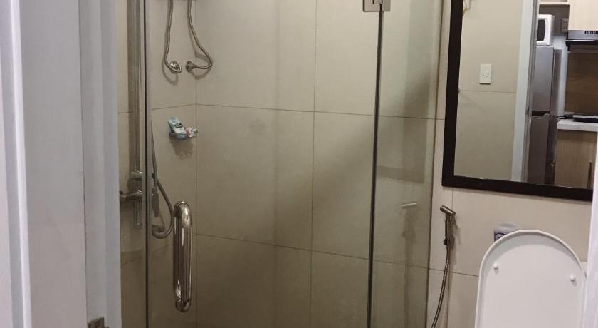 a shower stall with a toilet and a shower curtain, Condotel in Baguio