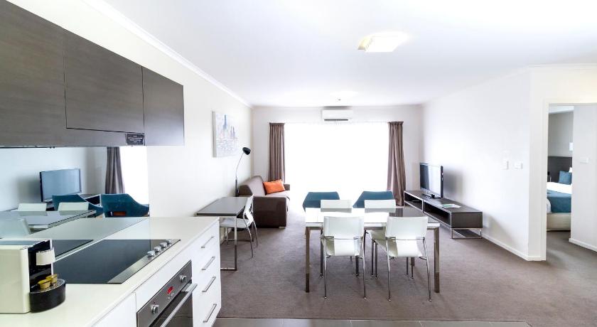 a kitchen with a table and chairs in it, Abode Tuggeranong in Canberra