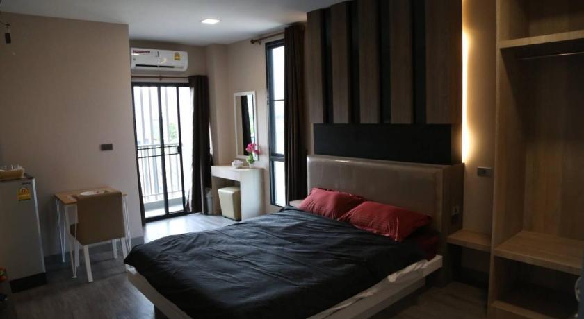 a bedroom with a large bed and a large window, Ben at Salaya in Nakhon Pathom